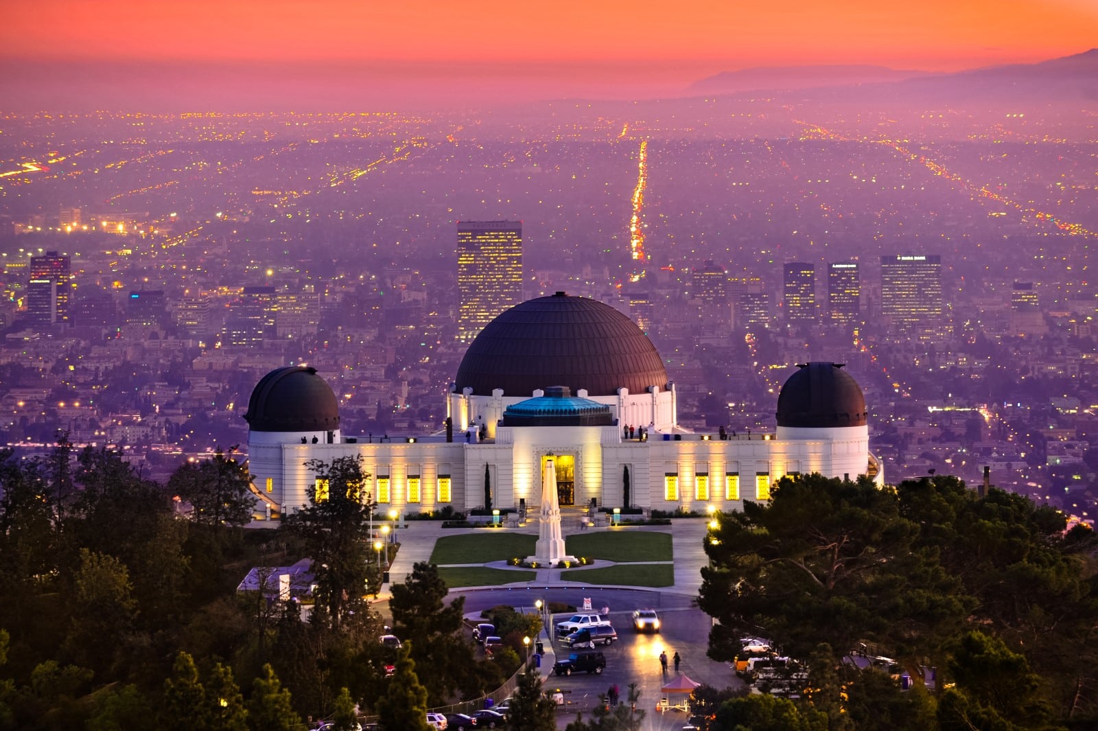 Historic famous Griffith Park Observatory at Sunset with Los Angeles city lights sparkling in background and Catalina Island in distance